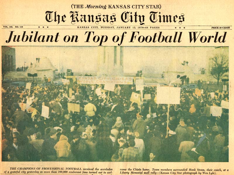 Scan de la première page du Kansas City Times. Titre : Jubilant au sommet du monde du football. Photographie : Grande foule rassemblée dans la zone à l'extérieur du Liberty Memorial. Beaucoup tiennent des pancartes.