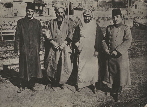 Sepia photograph of four WWI-era Turkish men dressed in Turkish military uniform or civilian clothing