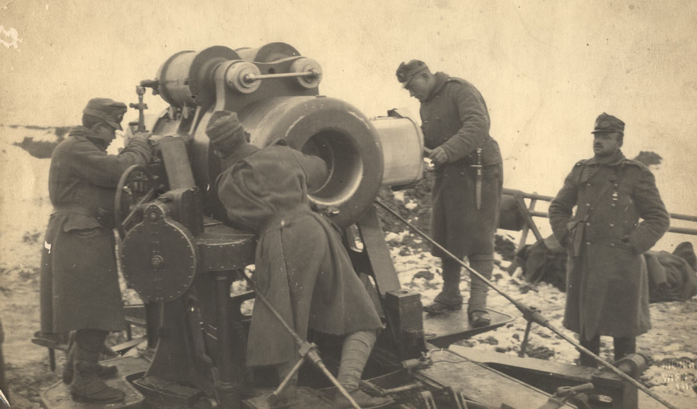 Soldiers gathered around a large mortar gun in a snowy field. 