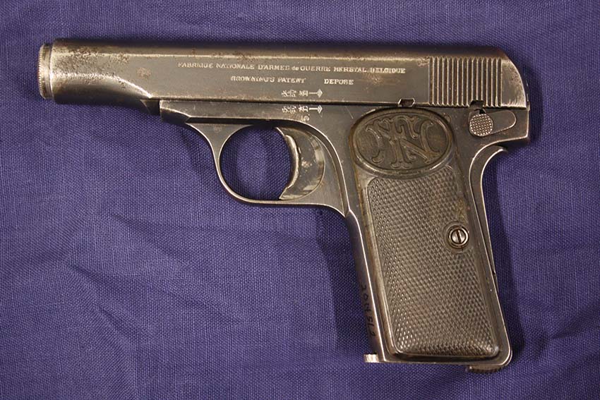 Photograph of a WWI-era pistol lying on a fabric background