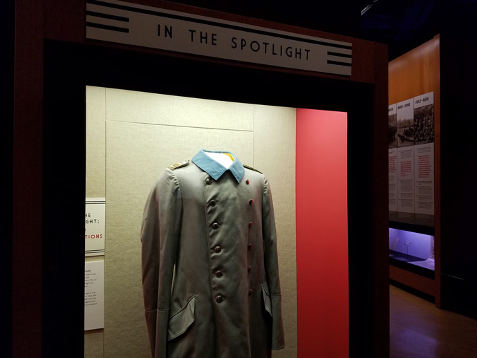 Photograph of a WWI-era overcoat in a museum display case