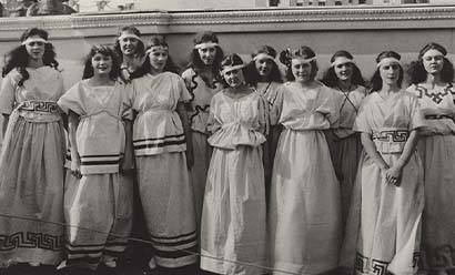Black and white photo of a group of young white women dressed in classical-Greek-inspired robes