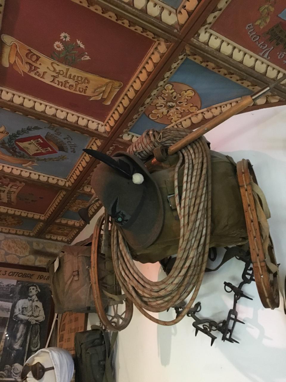 A display of historic alpine climbing gear hanging from a museum wall.