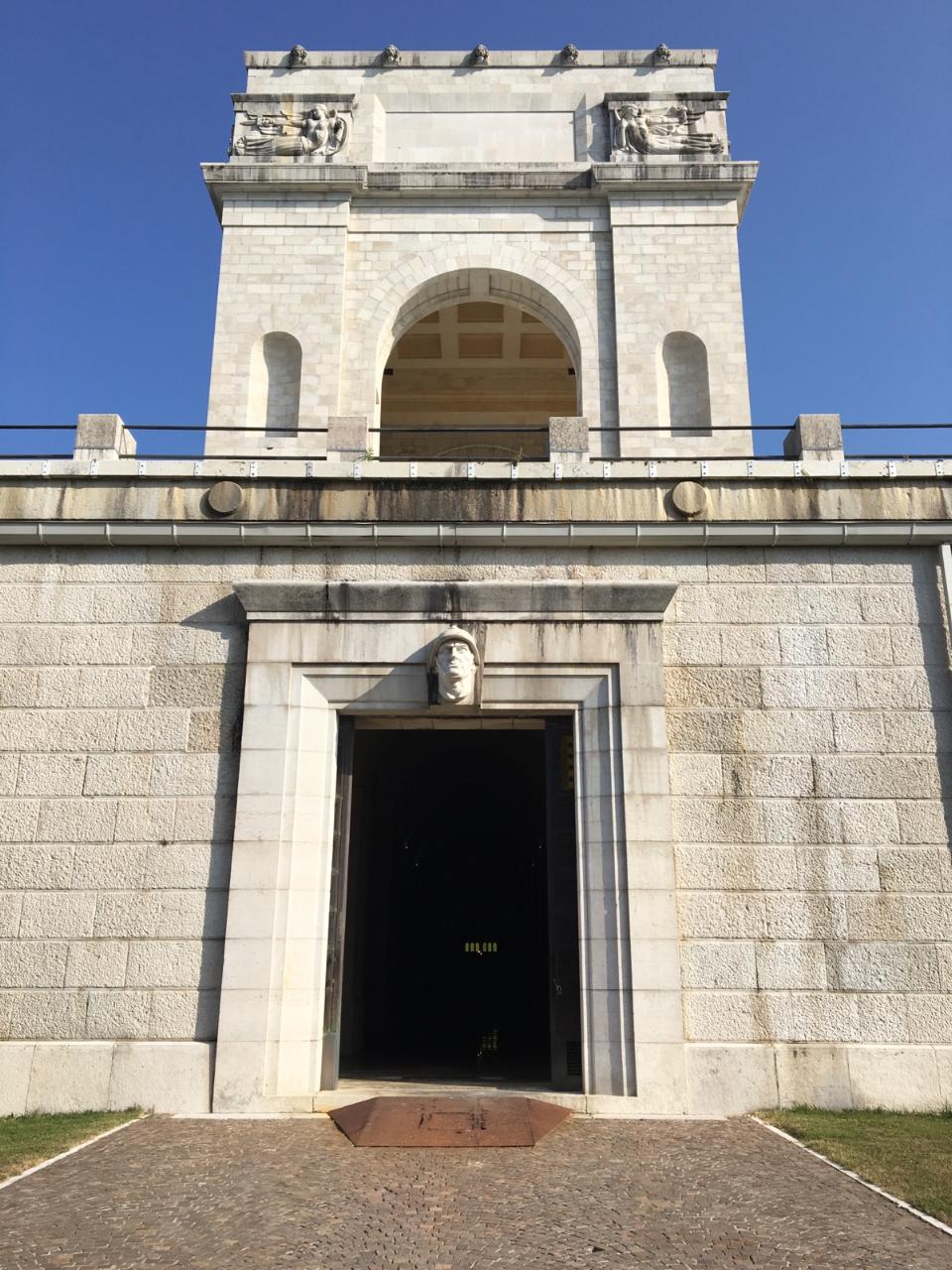 A dark doorway with a rectangular tower rising above it.