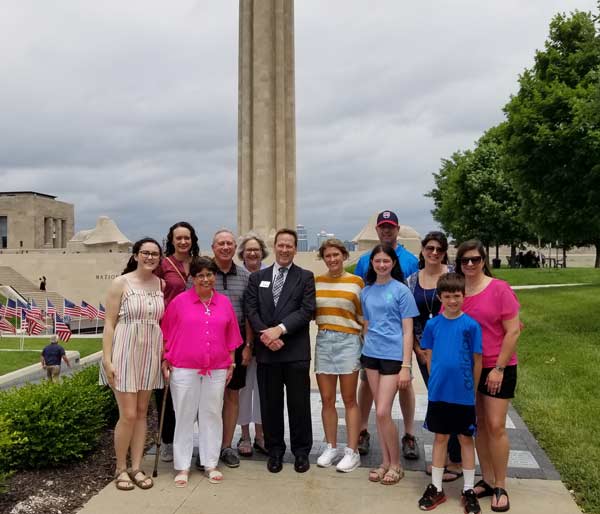 Photograph of a family group spanning several generations posing in front of the Liberty Memorial.