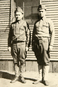 Sepia photo of two men in uniform standing at attention