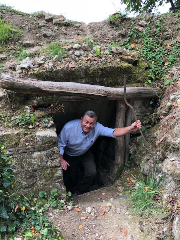 Modern photograph of a man emerging from an underground bunker in a trench.
