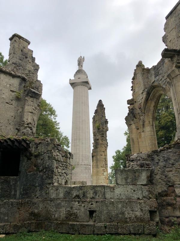 A new monument standing amidst ruined stone buildings.