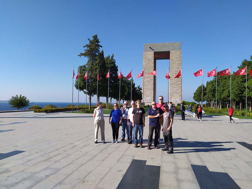 The tour group in front of a memorial shaped like a tall rectangular arch