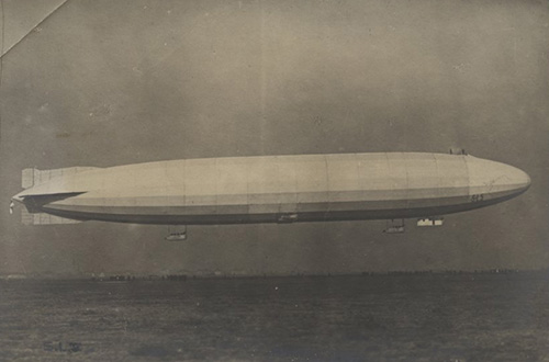 အဖြူအမည်းဓာတ်ပုံ။ လေထဲတွင် အလွန်ရှည်လျားသော zeppelin ၏ ဘေးဘက်မြင်ကွင်း