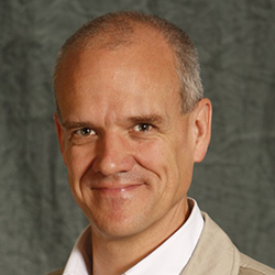 Headshot of a smiling white man with close-cropped grey hair