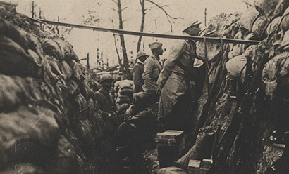 Black and white photo of French soldiers looking over the edge of a trench