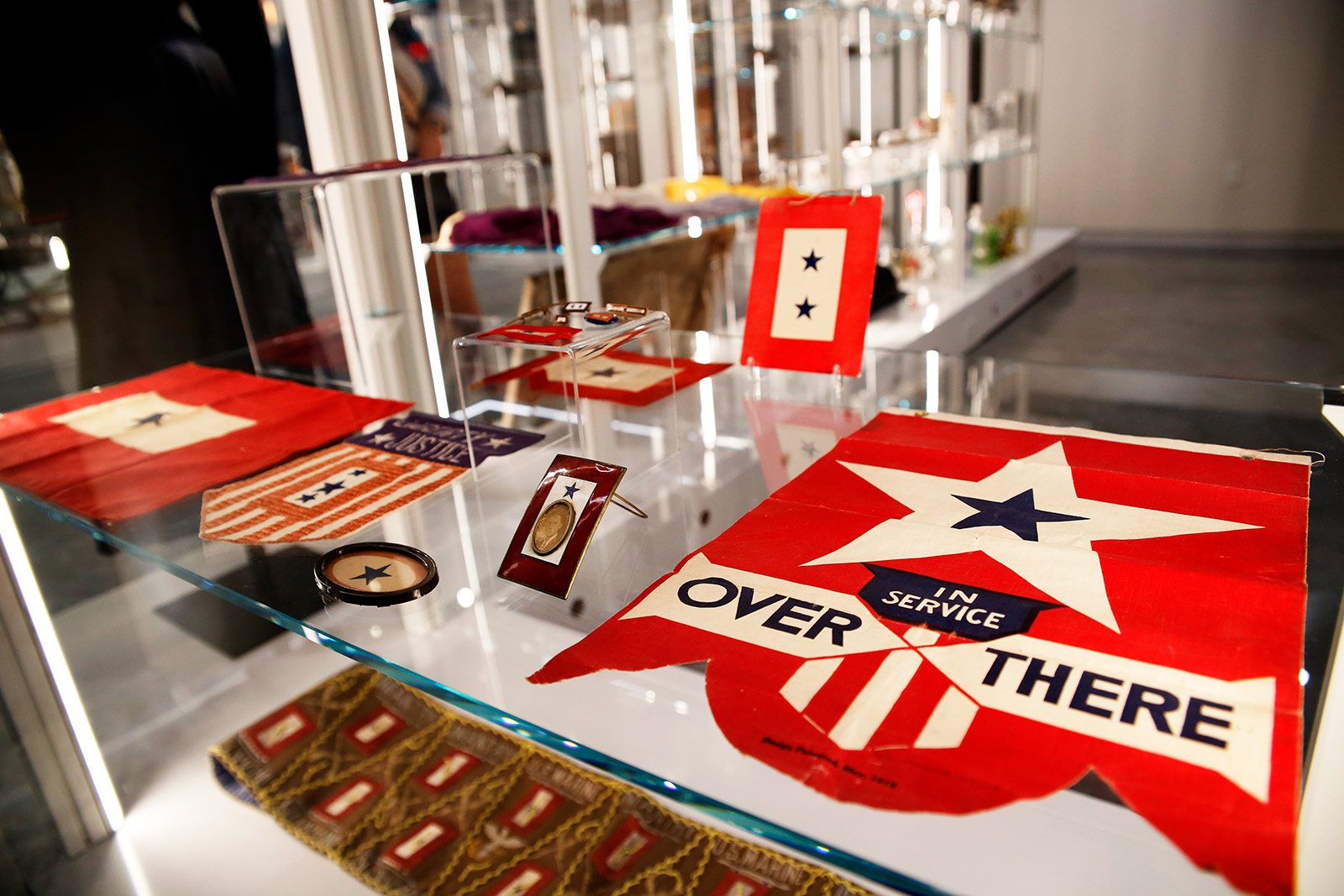 Modern photograph of an array of flags, banners, cards, pins and other memorabilia all displaying blue stars of different designs.