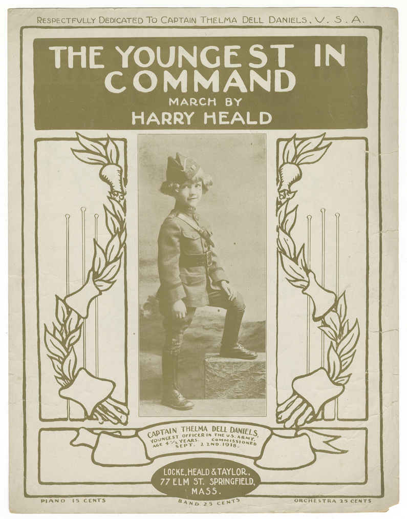 Couverture d'un livre de partitions. Texte : « Le plus jeune aux commandes / Marche par / Harry Heald » Image : une photographie en noir et blanc d'une jeune fille portant un uniforme militaire.