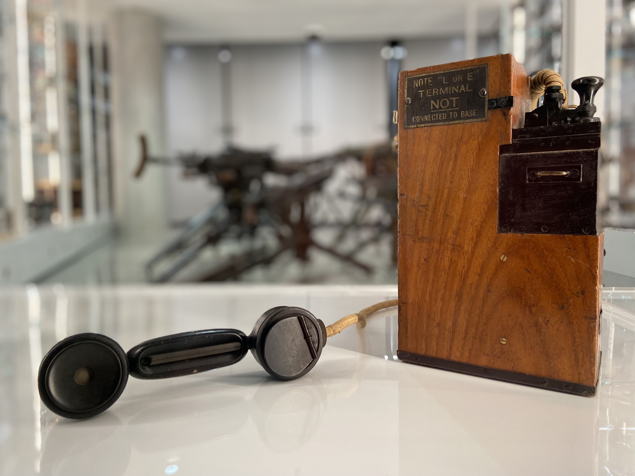 Photographie moderne d'une boîte en bois sur laquelle dépassent des interrupteurs métalliques et d'autres mécanismes, notamment un combiné téléphonique.