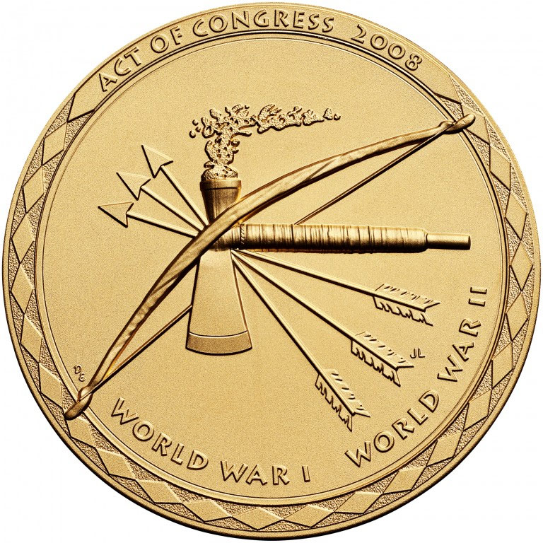 Photographie moderne d'une médaille de couleur bronze-or gravée d'un arc, de trois flèches empennées et d'une hachette de pipe.