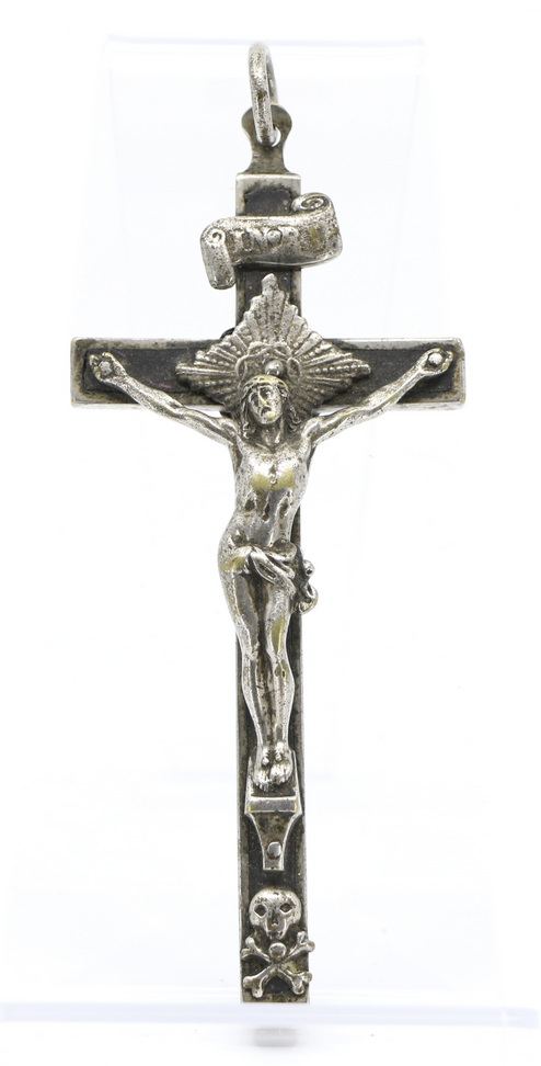 Photographie moderne d'un pendentif crucifix en argent comprenant des représentations d'un parchemin et d'un crâne et d'os croisés.