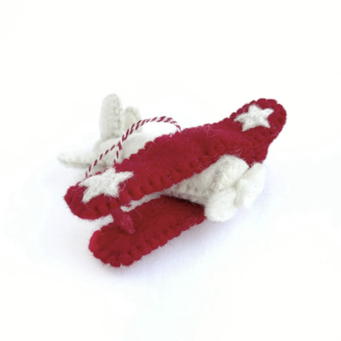 A small red and white felted model of a biplane