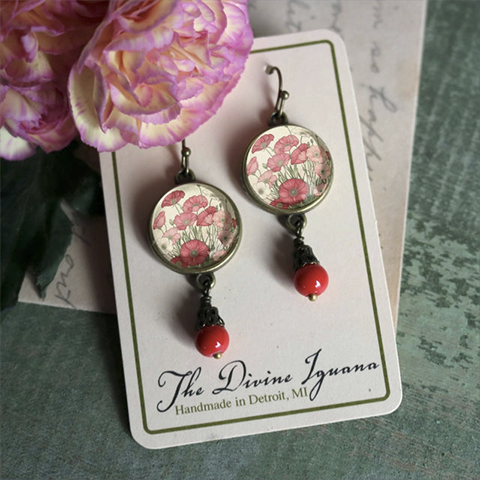 Dangling earrings with poppy-red beads and small paintings of poppies framed in brass and glass.