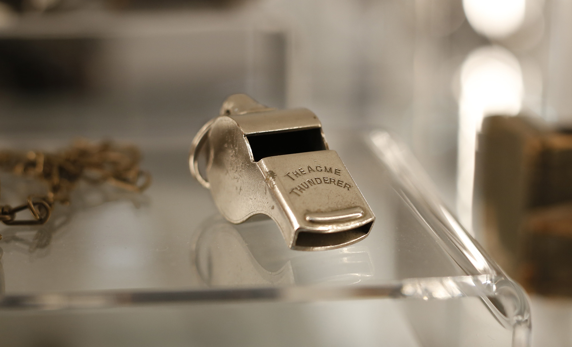 Metal whistle shaped like a sports whistle. Engraved with 'The ACME Thunderer'