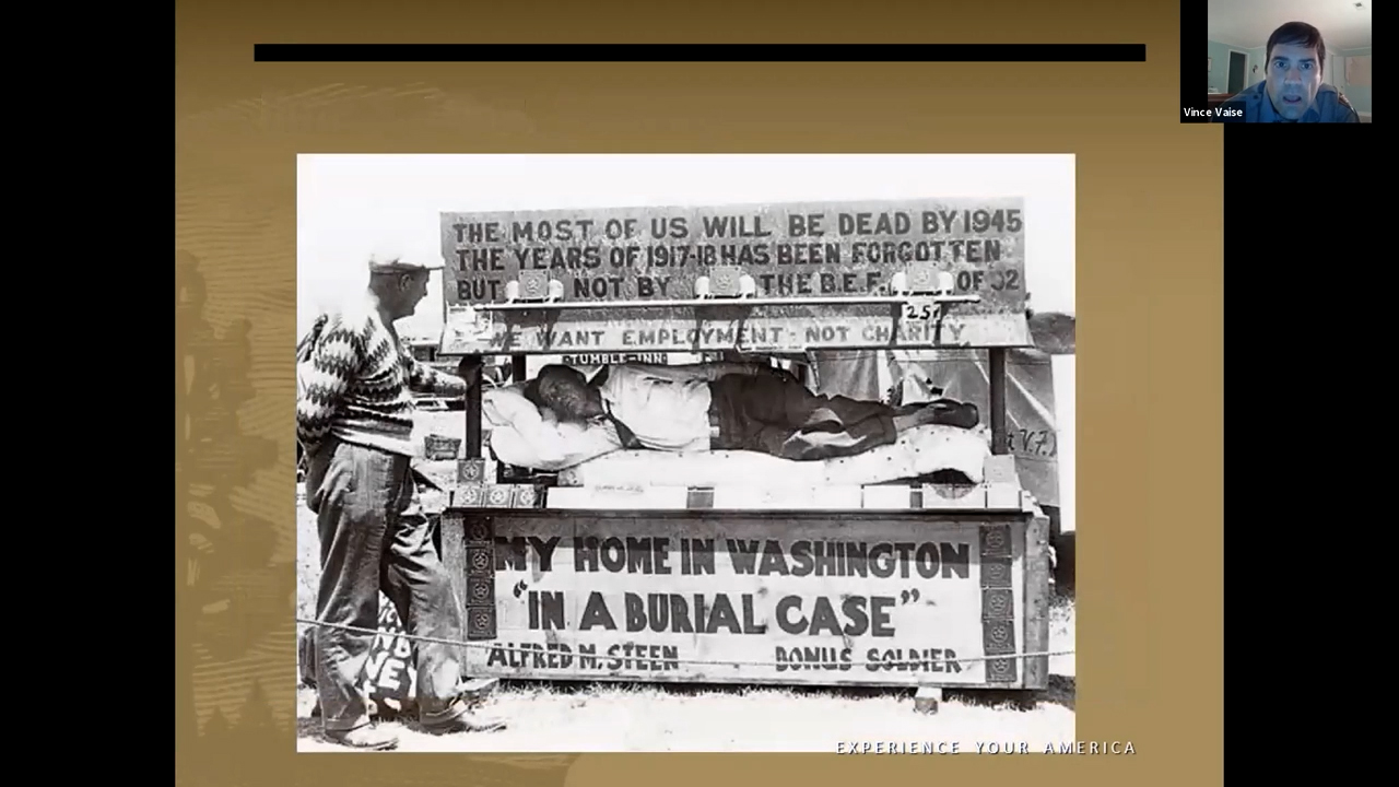 Makeshift combination booth and shelter with big signs pasted out front. A man lies in the shelter.