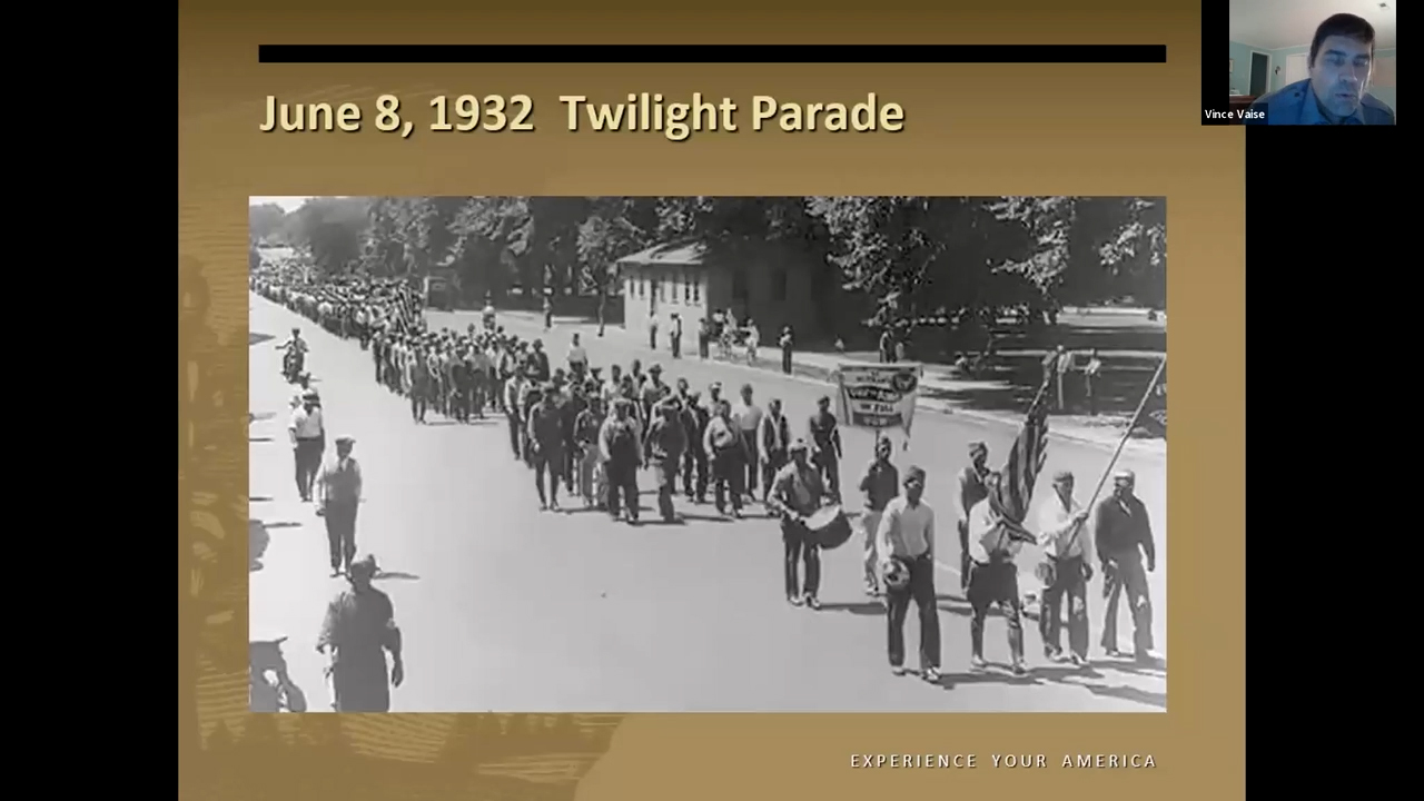 Black and white photo of a column of men marching down a city street
