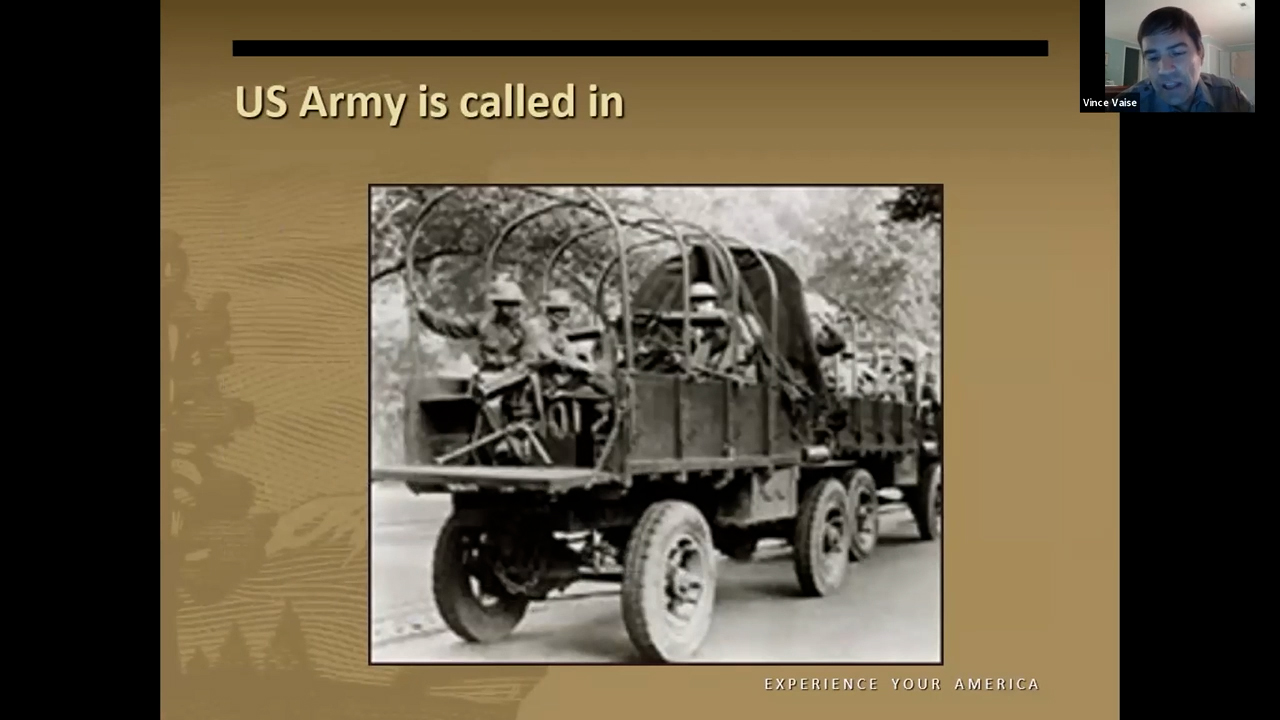 Black and white photo of a convoy of trucks carrying soldiers
