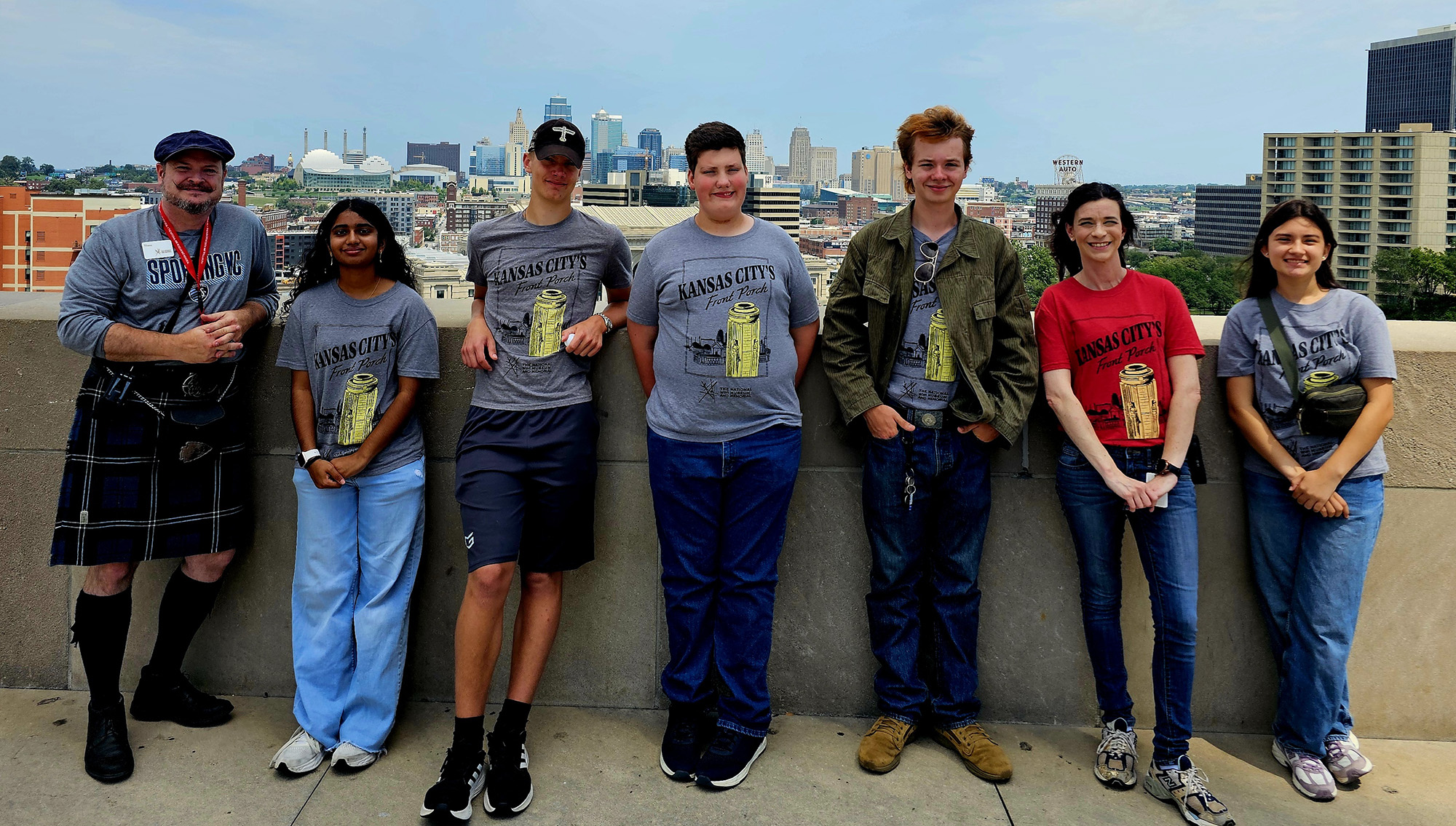 Two adults and five teenagers pose for a casual picture on Memorial Courtyard