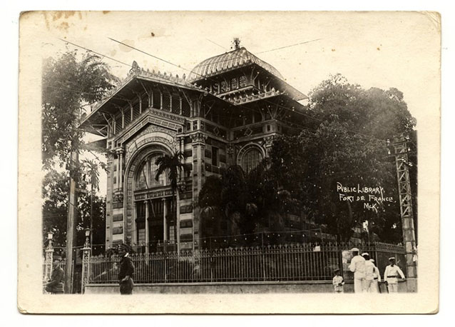 Black and white photo of an elaborately adorned building surrounded by palm trees