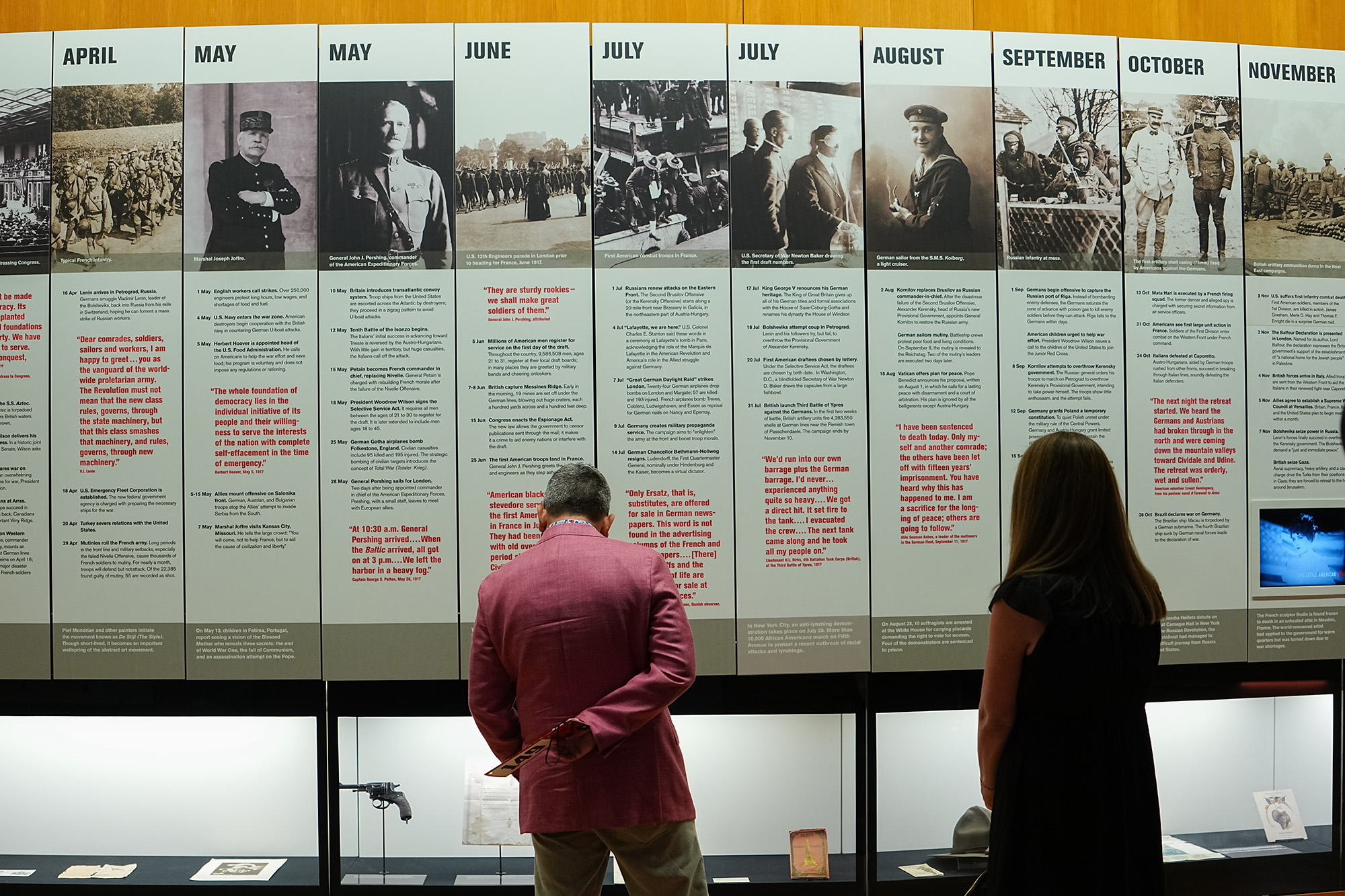 Two museum guests read from a large written display on a gallery wall