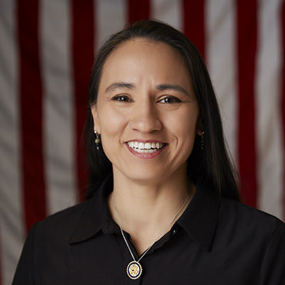 Black-haired, brown-skinned woman wearing a black collared shirt