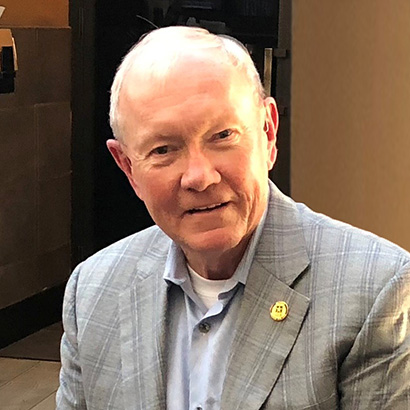 Older white man wearing a grey blazer