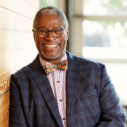 Middle-aged Black man in a blue checked suit and bowtie
