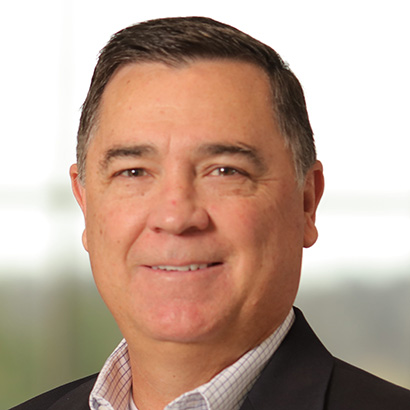 Middle-aged white man with short dark hair wearing a black suit jacket