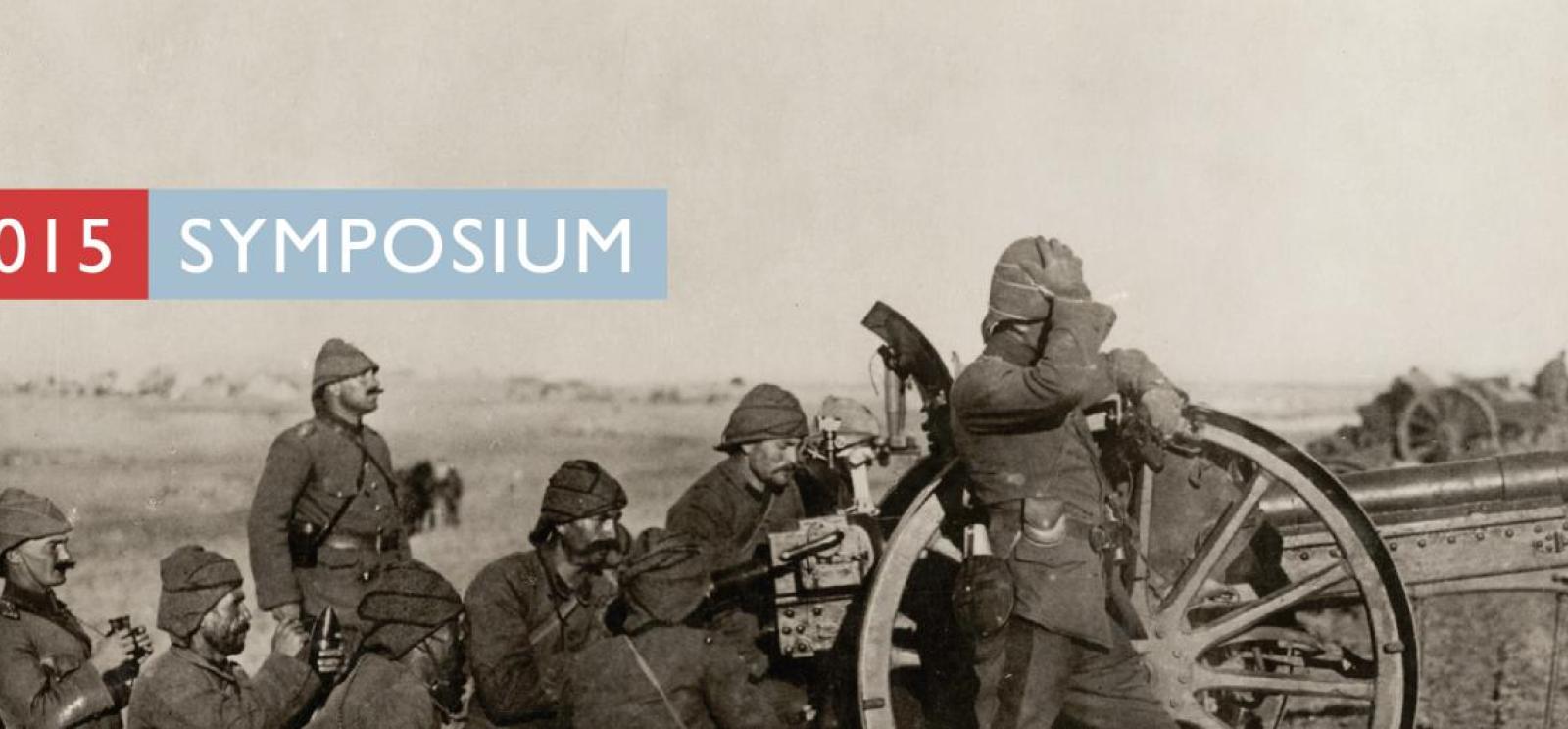 Background image: black and white photograph of soldiers in a field grouped behind a trench gun. Text: 2015 Symposium