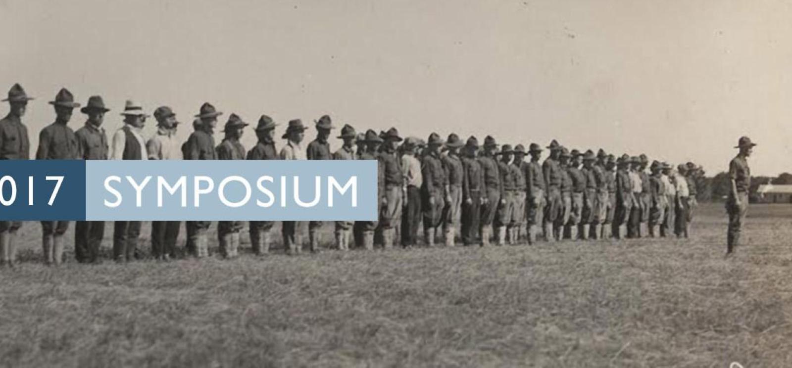 Background image: A line of soldiers in an empty field. Text: 2017 Symposium