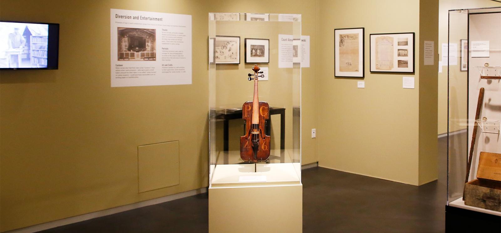 Modern photograph of a handmade violin in a clear exhibit case