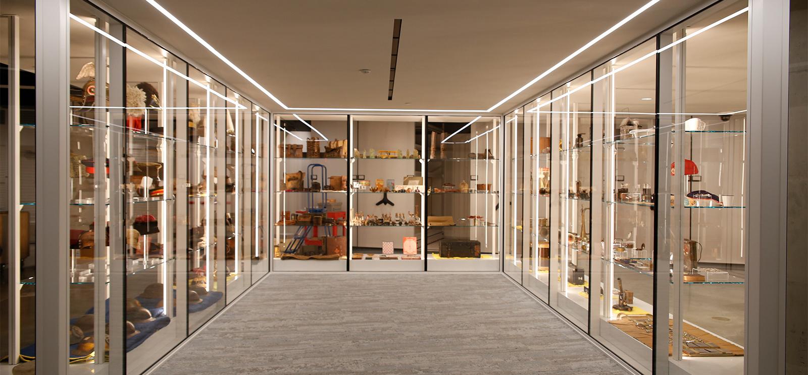 Modern photograph of an alcove bounded on three sides by glass display cases, filled with WWI artifacts