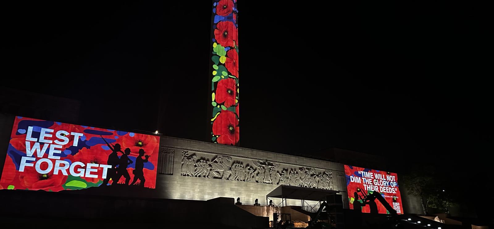 Modern photograph of the Liberty Memorial Tower and North Terrace Wall covered in poppy graphics