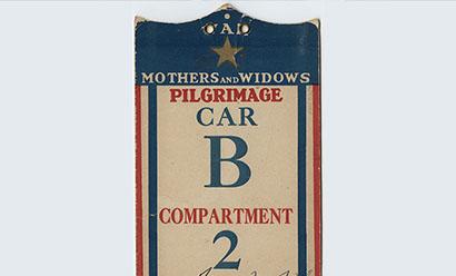 Scanned card shaped like an elongated shield. Striped in red and blue. Gold star printed at top. Text: Mothers and Widows Pilgrimage. Car B. Compartment 2.