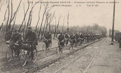 Black and white photograph of a double line of soldiers riding bicycles towards the viewer's left side