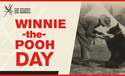 Image: black and white photo of a man in WWI uniform bending over to shake the paw of a smallish black bear. Text: 'Winnie-the-Pooh Day'