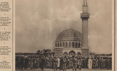 Crop of a scan of a vintage magazine page featuring a black and white photo of a small mosque surrounded by people