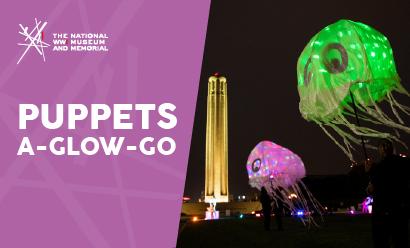 Modern photograph of giant colorful glowing jellyfish puppets floating in the air with the Liberty Memorial Tower in the background