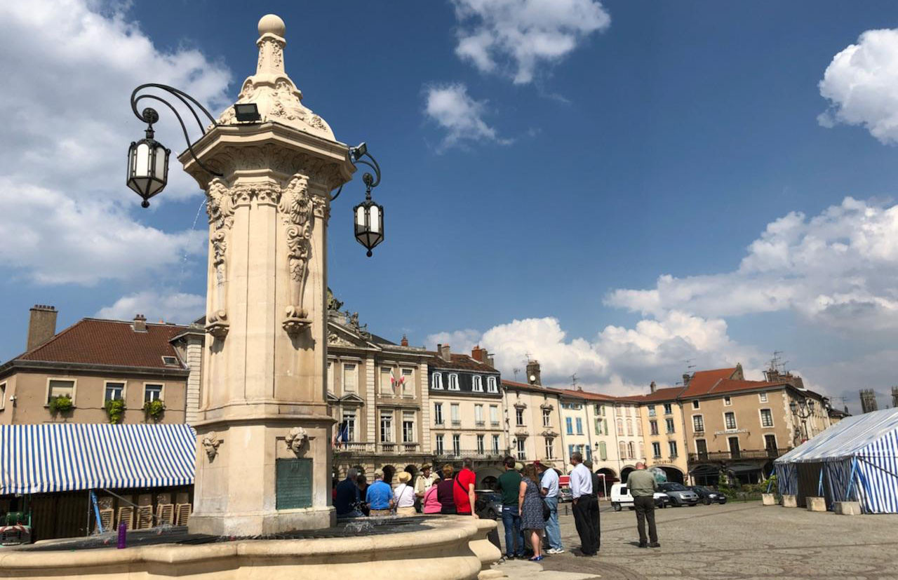 City square with a tall fountain in the middle
