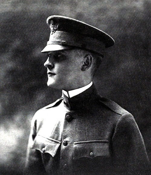 Black and white portrait photograph of a young white man in WWI military uniform and cap