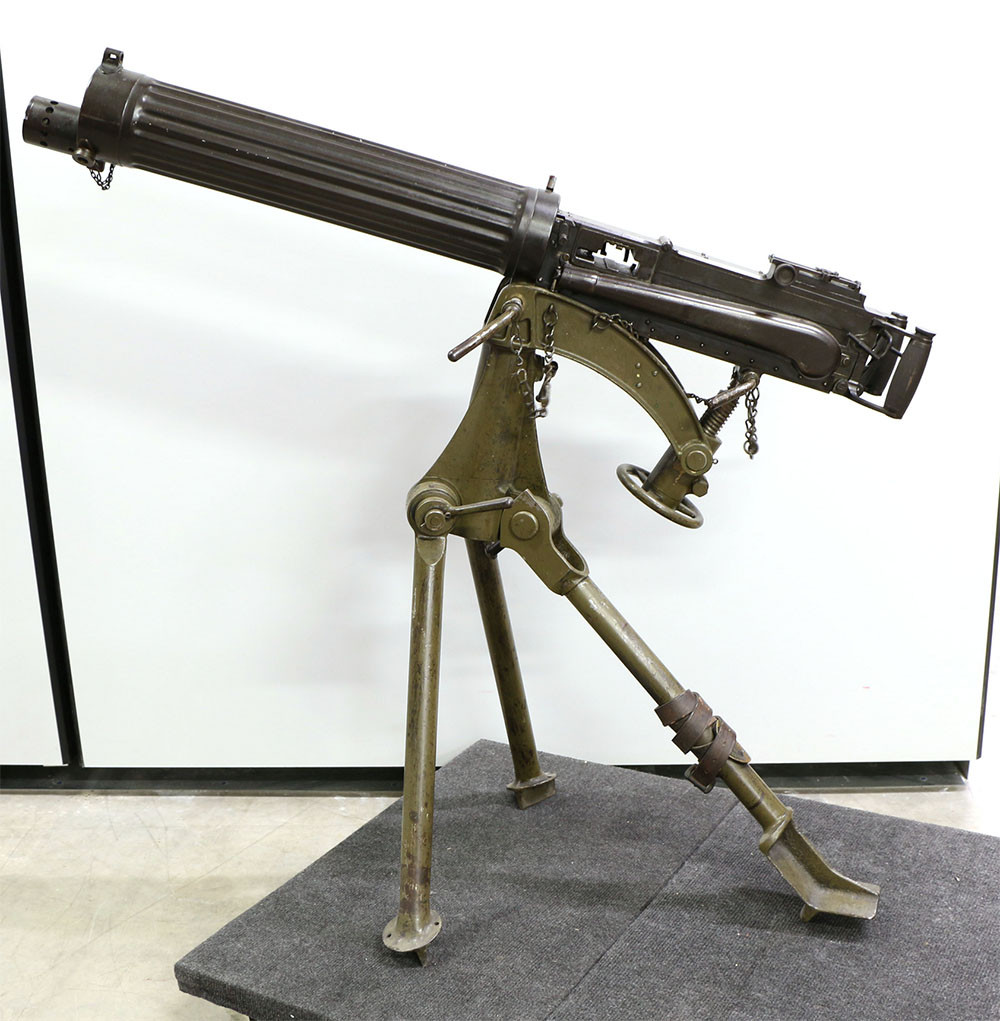 Modern photograph of a Vickers machine gun set up on a metal tripod in a museum storage area
