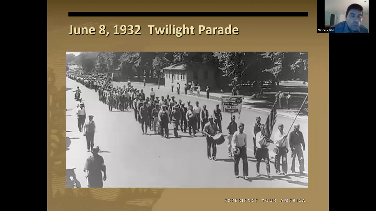 Black and white photo of a column of men marching down a city street