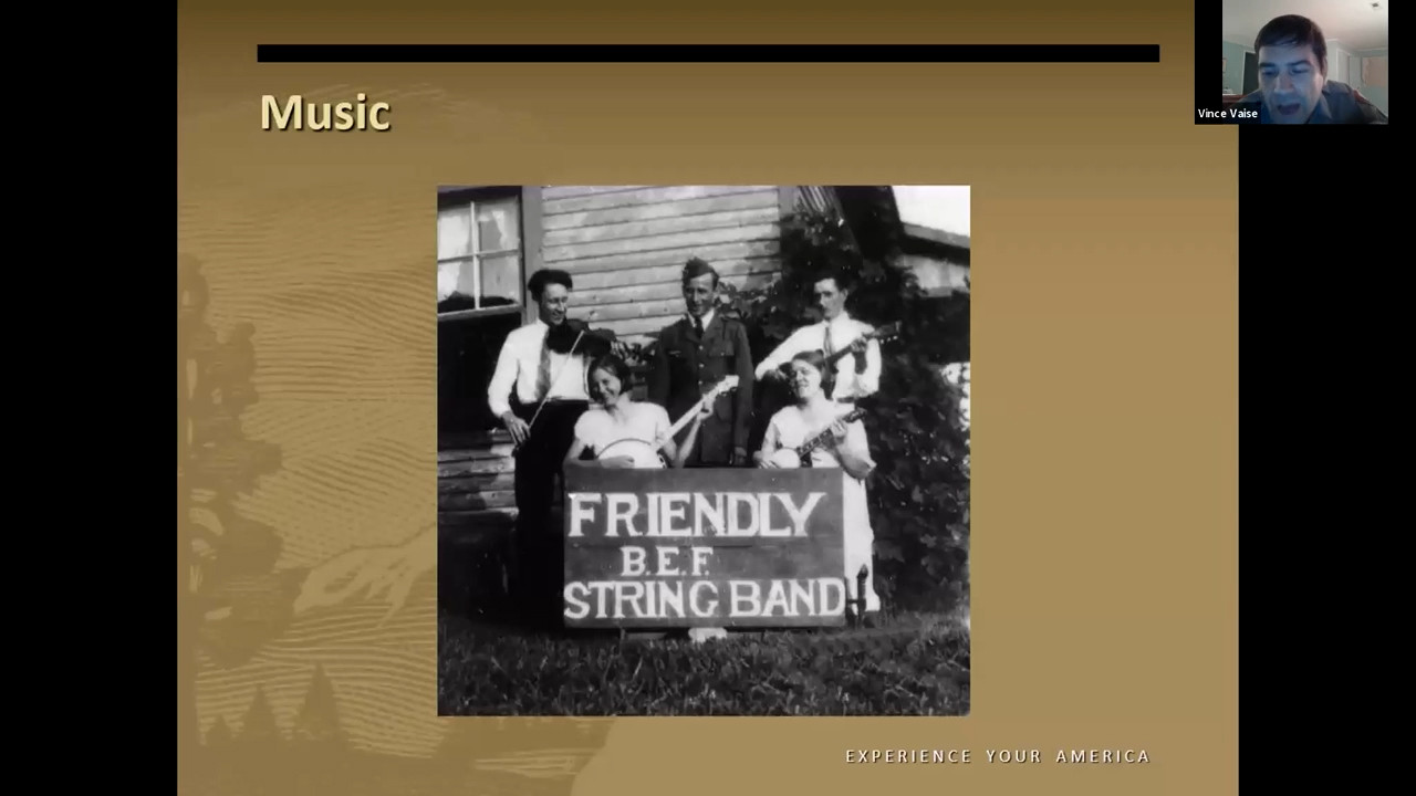 Black and white photo of a group of people playing instruments. Their banner reads 'Friendly B.E.F String Band'