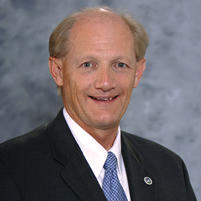 Older balding white man wearing a dark suit